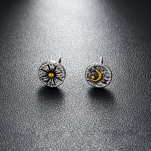 Macro shot of asymmetric sun and moon vintage silver studs on black leather