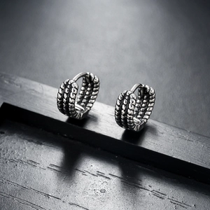 Close-up of vintage silver hoop earrings with three-row textured industrial metal finish