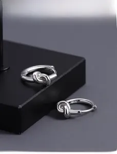 Vue macro détaillée de boucles d'oreilles créoles en argent S925 avec design de nœud