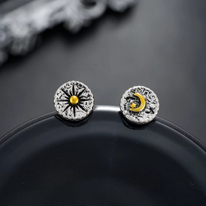 Macro detail of sun and moon stud earrings with vintage hammered silver and gold accents