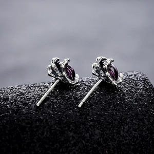 Macro view of S925 silver dragon claw stud earring with a purple crystal gemstone
