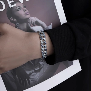 Gros plan du bracelet gourmette argenté avec émail bleu sur le poignet d'un mannequin