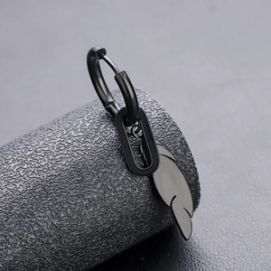 Vue macro d'une boucle d'oreille plume en titane noir au design minimaliste et poli