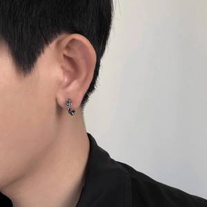 Close-up of vintage silver rose hoop earring with detailed 3D carving on male model