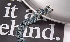 Gros plan du bracelet à maillons cubains avec émail marbré bleu étoilé sur métal