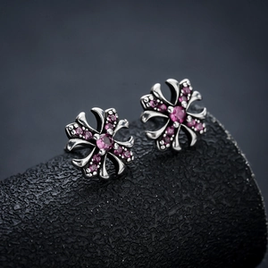 Dettaglio di orecchini a croce gotica con zirconia rosa su metallo argentato vintage