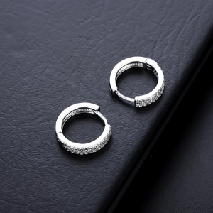 Vue macro de boucles d'oreilles créoles en argent serties de deux rangées de zircons