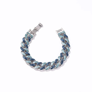 Détail macro de l'émail bleu sur un bracelet à maillons cubains argentés avec fermoir