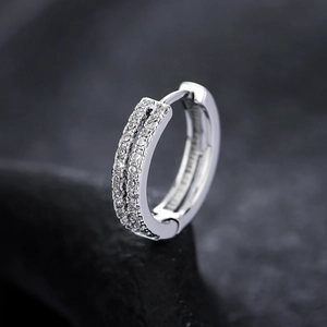 Vue macro de boucles d'oreilles argentées avec double rangée de zircons micro-pave
