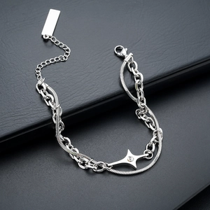 Detail of silver double-layer bracelet with star pendant on black leather texture