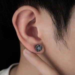 Macro shot of a vintage magnetic ear cuff with black zircon and beaded metal texture