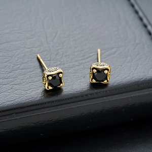 Detail of vintage gold dragon claw stud earrings featuring a square black zircon stone