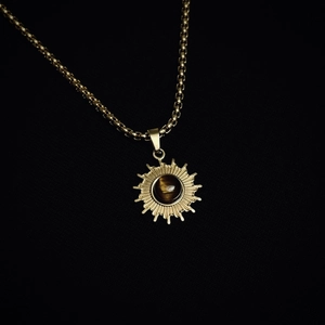 Detailansicht des Sonnenanhängers mit Tigerauge-Stein an goldener Boxkette