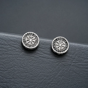 Macro shot of vintage silver viking compass magnetic earrings with black zircon stones