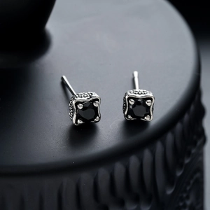 Detail of vintage silver dragon claw stud earrings with square black zircon stones