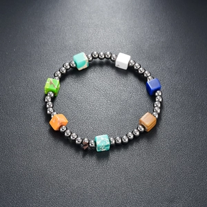 Macro shot of colorful cube stones and dark metallic beads on an elastic bracelet