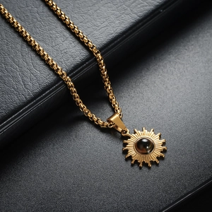 Detailaufnahme eines goldenen Sonnenanhängers mit schwarzem Obsidian am Boxkette
