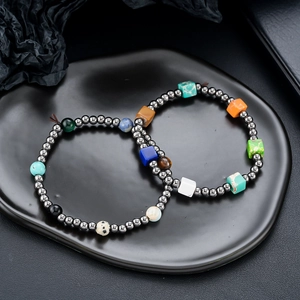Detailed close-up of dark grey hematite beaded bracelets with colorful natural gemstones
