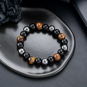Obsidian, tiger eye and hematite beaded bracelet for men on a black textured tray