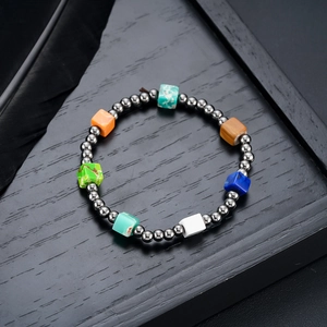 Close-up of beaded bracelet with colorful square natural stones and polished metal beads