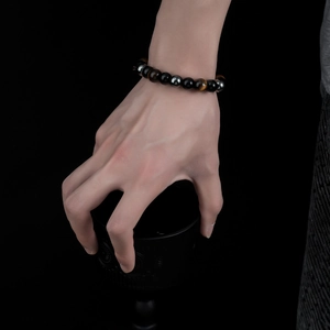 Detail of 8mm men's tiger eye and obsidian beaded bracelet with elastic cord on wrist