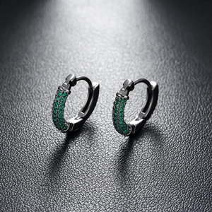 Detailed close-up of dark gunmetal hoop earrings with emerald green zircon paving