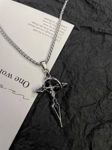 Close-up of gothic silver cross pendant on beaded chain with sharp metallic details