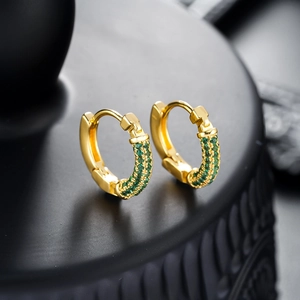Macro view of gold hoop earrings with emerald green zircon micro-pave setting