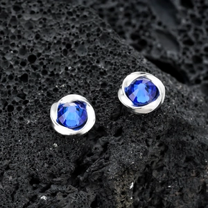 Pair of Mobius magnetic ear clips with blue zircon set in silver floral base