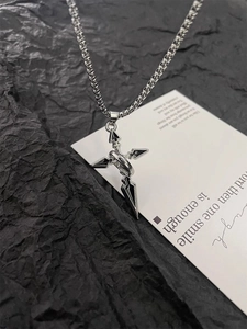 Close-up of gothic cross and sword pendant necklace in polished silver steel