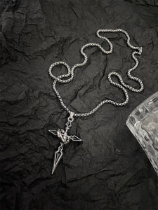Detailed close-up of a silver cross pendant with a deconstructive spiked industrial design