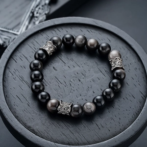 Macro view of natural silver obsidian beads with vintage engraved metal spacers
