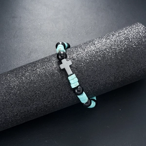 Detail of beaded bracelet with black obsidian beads, turquoise discs and metal cross