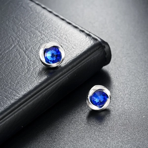 Mobius magnetic earrings with blue zircon in polished twisted metal setting for men and women