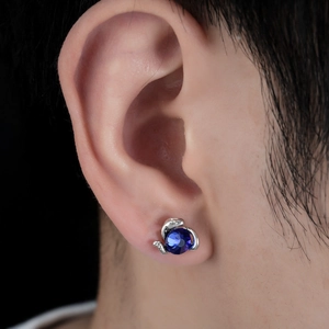 Détail macro du clip d'oreille magnétique argenté avec pierre bleue sur oreille du mannequin