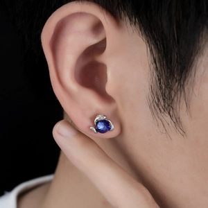 Détail du clip magnétique Medusa Eye avec gemme bleue et design serpentin argenté