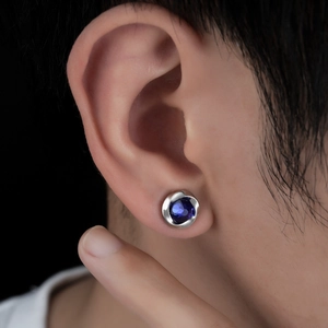 Close-up of Mobius magnetic ear clip featuring blue zircon and spiral silver border design