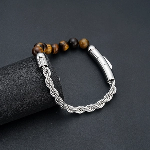Macro detail of brown tiger eye stones and silver stainless steel twist chain bracelet