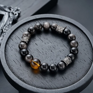 Detailed macro shot of obsidian beads and amber stone with vintage silver spacers