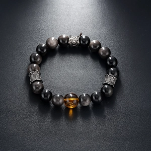 Detailed close-up of natural silver obsidian beads with amber bead and silver spacers