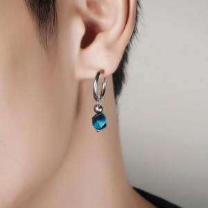 Gros plan sur la boucle d'oreille avec perle bleue facettée et anneau argent