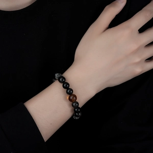 Natural silver obsidian beaded bracelet with centerpiece amber and silver charm on wrist