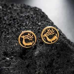 Vintage gold elk stud earrings with reindeer design on black volcanic rock background