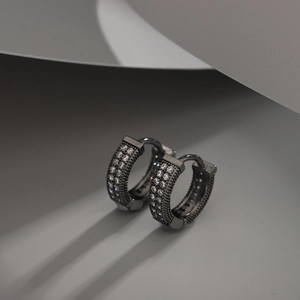 Detailed close-up of gunmetal hinged hoop earrings with triple-row crystal pave setting