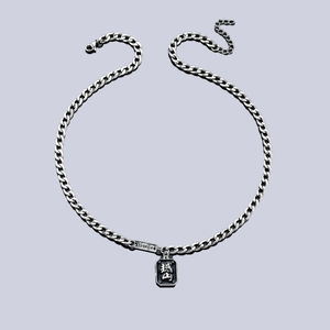 Détail macro du pendentif rectangulaire argenté avec émail noir et gravure chinoise