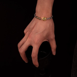 Dettaglio del bracciale vintage stile tibetano con ciondoli dorati e maglie argentate