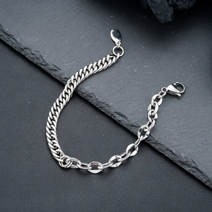 Detail eines klobigen Edelstahl-Kettenarmbands mit Karabinerverschluss auf schwarzem Stein