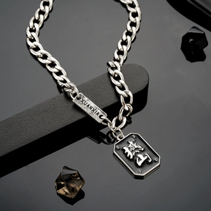 Gros plan de la chaîne hip-hop avec pendentif rectangulaire noir et motif gravé