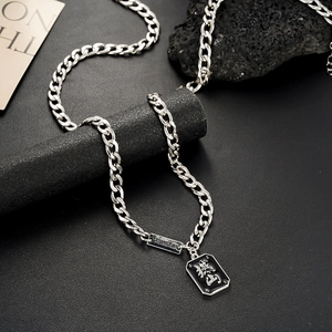 Détail du collier chaîne en acier titane argenté avec plaque carrée et gravure chinoise