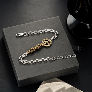 Makroansicht der silbernen O-Kette mit goldenem Ethno-Anhänger auf Geschenkbox